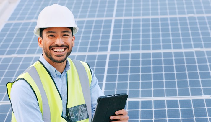 Smiling engineer infront of solar panels
